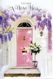 A serene Greenford doorway scene shows a pale pink front door bathed in gentle light, framed by abundant trails of lavender wisteria that pour down from above in soft, fragrant clusters. The flowers create a natural arch that brushes against the whitewashed walls and a coordinating pastel shutter, giving the entrance a calm, storybook charm you might stumble upon while walking home from Perivale Park or along Oldfield Lane. At the foot of the door, set neatly on the step, sits a simple yet elegant metal bucket transformed into a housewarming bouquet. It overflows with lush white and cream roses, each bloom full and rounded, their velvety petals opening outwards as if in a quiet sigh of contentment. Wisps of soft green foliage thread gently through the arrangement, adding texture and a fresh, garden-picked feeling. Around the base of the bucket, a tender pink ribbon is tied in a loose, graceful bow, its colour echoing the warm blush of the door and binding the whole composition together visually. Sunlight filters through the wisteria leaves, casting delicate shadows that dance across the stone step and metal pail, suggesting a mild afternoon just as the day begins to soften. The scene radiates gentle optimism and welcome, perfectly suited to celebrating someone's new address in Greenford, and feels like the kind of floral moment a caring neighbour or local florist would place on the doorstep to say, You're home now; may this place be filled with joy, comfort, and lasting memories.